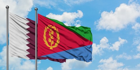 Qatar and Eritrea flag waving in the wind against white cloudy blue sky together. Diplomacy concept, international relations.