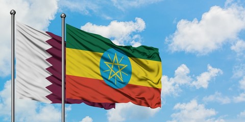 Qatar and Ethiopia flag waving in the wind against white cloudy blue sky together. Diplomacy concept, international relations.