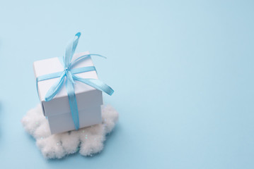 white gift box on blue background with snowflake, copy space for season greeting Happy New Year, AF point selection and blurred.