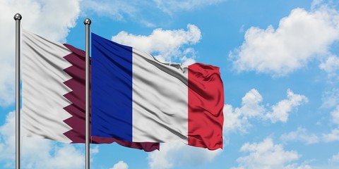 Qatar and France flag waving in the wind against white cloudy blue sky together. Diplomacy concept, international relations.