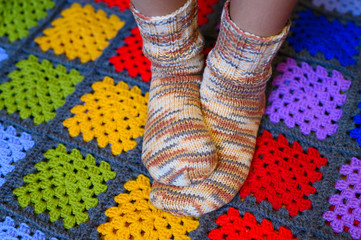 children's feet in warm wool socks on a colorful check plaid