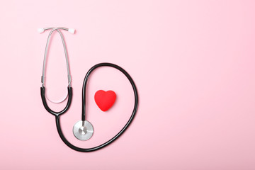 Stethoscope and heart on wooden color background. Health, medicine