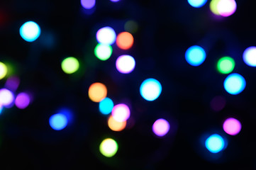 blurred night multicolored glowing lights on black background. new year and christmas concept