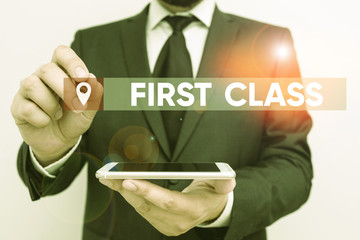 Conceptual hand writing showing First Class. Concept meaning the most expensive and most luxurious class of accommodation Male human wear formal work suit hold smartphone using hand © A