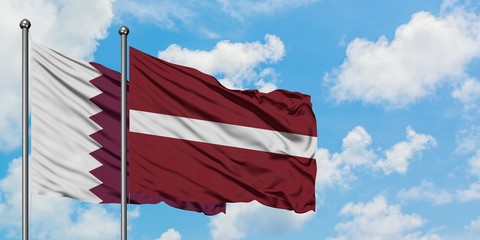 Qatar and Latvia flag waving in the wind against white cloudy blue sky together. Diplomacy concept,...