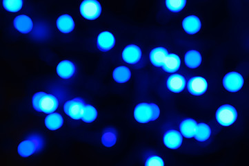 blurred night blue glowing lights on black background. new year and christmas concept