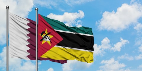 Qatar and Mozambique flag waving in the wind against white cloudy blue sky together. Diplomacy concept, international relations.