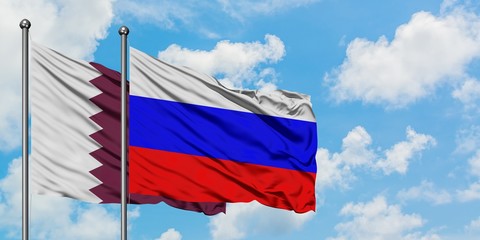 Qatar and Russia flag waving in the wind against white cloudy blue sky together. Diplomacy concept, international relations.