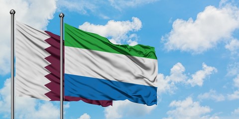 Qatar and Sierra Leone flag waving in the wind against white cloudy blue sky together. Diplomacy concept, international relations.