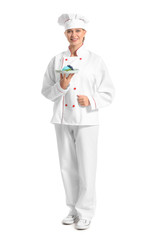 Female confectioner with tasty dessert on white background