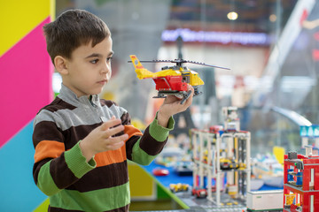 a boy plays with a toy helicopter in kindergarten