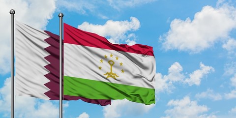 Qatar and Tajikistan flag waving in the wind against white cloudy blue sky together. Diplomacy concept, international relations.