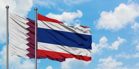 Qatar and Thailand flag waving in the wind against white cloudy blue sky together. Diplomacy concept, international relations.