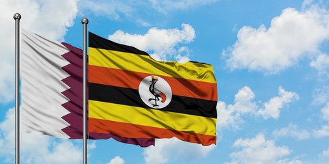 Qatar and Uganda flag waving in the wind against white cloudy blue sky together. Diplomacy concept,...