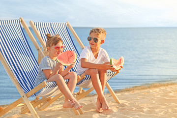 Little children eating watermelon on sea beach