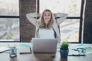 Photo of beautiful blond business lady looking notebook table holding hands behind head speaking...