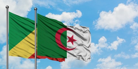 Republic Of The Congo and Algeria flag waving in the wind against white cloudy blue sky together....