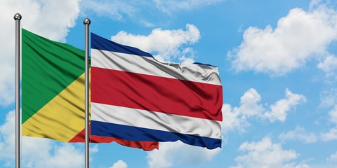 Republic Of The Congo and Costa Rica flag waving in the wind against white cloudy blue sky...