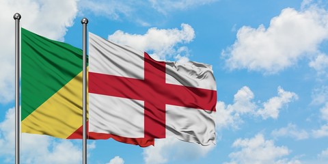 Republic Of The Congo and England flag waving in the wind against white cloudy blue sky together....