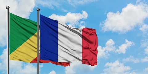 Republic Of The Congo and France flag waving in the wind against white cloudy blue sky together....