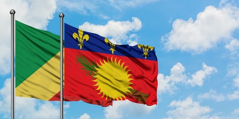 Republic Of The Congo and Guadeloupe flag waving in the wind against white cloudy blue sky together. Diplomacy concept, international relations.