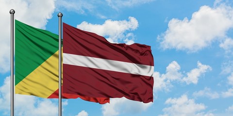 Republic Of The Congo and Latvia flag waving in the wind against white cloudy blue sky together....