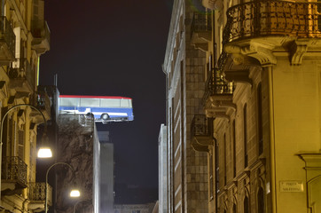 Turin, Piemonte, Italy. November 2019. A bus poised on the roof of a building. You can see the bus...
