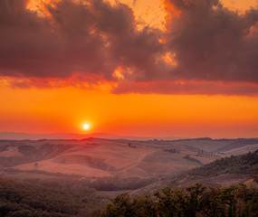 Beautiful sunset in Tuscany with the red sky over the rolling hills. Pink hour. Travel destination Tuscany, Italy