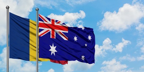 Romania and Australia flag waving in the wind against white cloudy blue sky together. Diplomacy...