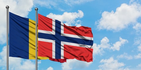 Romania and Bouvet Islands flag waving in the wind against white cloudy blue sky together....