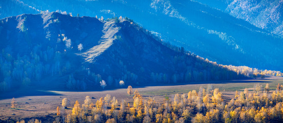 Autumn panoramic view, mountain slopes in the evening light, blue haze