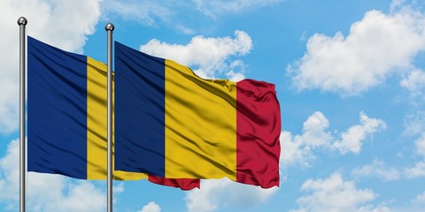 Romania and Chad flag waving in the wind against white cloudy blue sky together. Diplomacy concept,...