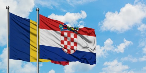 Romania and Croatia flag waving in the wind against white cloudy blue sky together. Diplomacy...