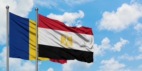 Romania and Egypt flag waving in the wind against white cloudy blue sky together. Diplomacy concept, international relations.