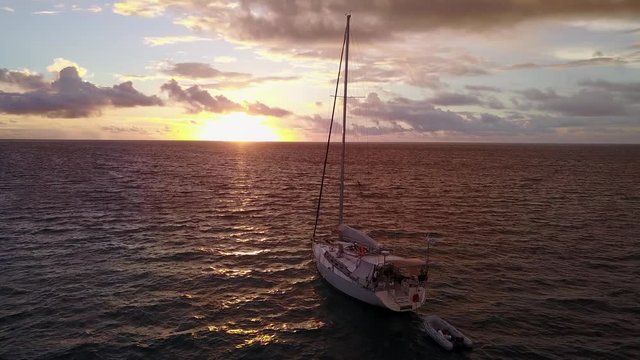 Sunset in Bahamas, boat sailing in open ocean, Aerial dusk