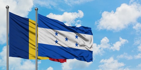 Romania and Honduras flag waving in the wind against white cloudy blue sky together. Diplomacy...
