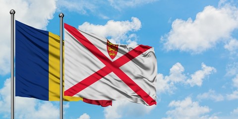 Romania and Jersey flag waving in the wind against white cloudy blue sky together. Diplomacy...