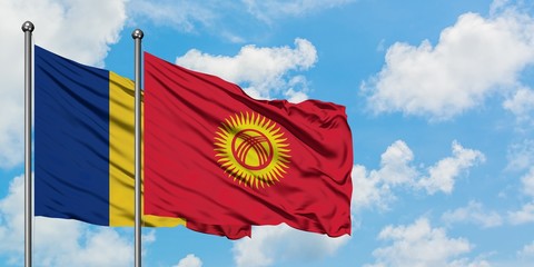 Romania and Kyrgyzstan flag waving in the wind against white cloudy blue sky together. Diplomacy...