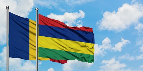 Romania and Mauritius flag waving in the wind against white cloudy blue sky together. Diplomacy concept, international relations.