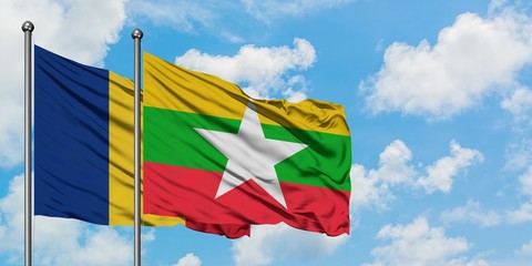 Romania and Myanmar flag waving in the wind against white cloudy blue sky together. Diplomacy...