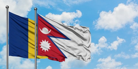 Romania and Nepal flag waving in the wind against white cloudy blue sky together. Diplomacy...