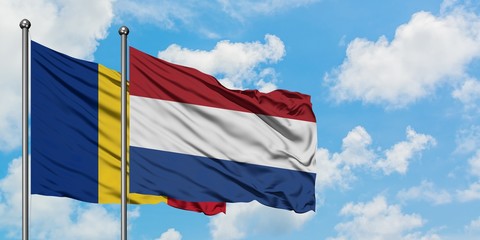 Romania and Netherlands flag waving in the wind against white cloudy blue sky together. Diplomacy concept, international relations.