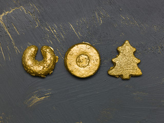many different golden christmas cookies on black, golden background