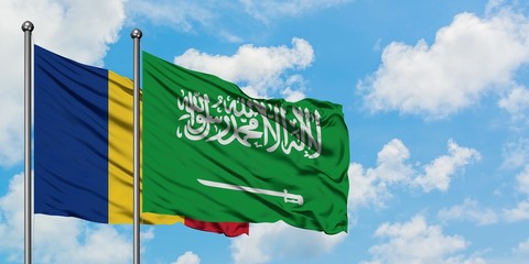 Romania and Saudi Arabia flag waving in the wind against white cloudy blue sky together. Diplomacy...