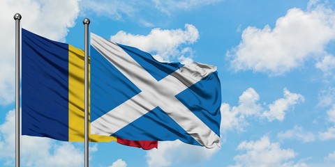 Romania and Scotland flag waving in the wind against white cloudy blue sky together. Diplomacy...