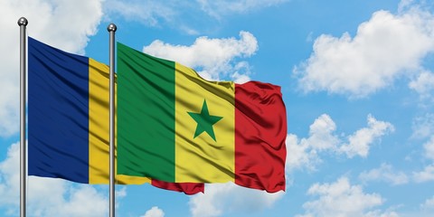 Romania and Senegal flag waving in the wind against white cloudy blue sky together. Diplomacy...