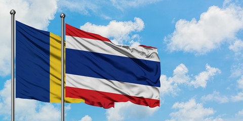 Romania and Thailand flag waving in the wind against white cloudy blue sky together. Diplomacy...