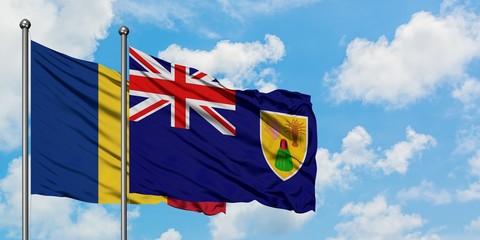 Romania and Turks And Caicos Islands flag waving in the wind against white cloudy blue sky together. Diplomacy concept, international relations.