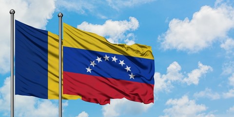 Romania and Venezuela flag waving in the wind against white cloudy blue sky together. Diplomacy...