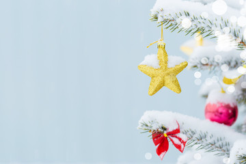 Christmas tree in snow background. New Year composition with fir tree, balls and lights and bokeh.